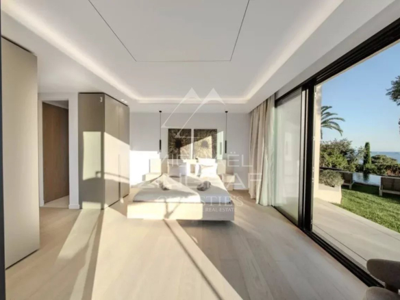 Chambre lumineuse d'une villa moderne avec vue sur le jardin à Antibes.