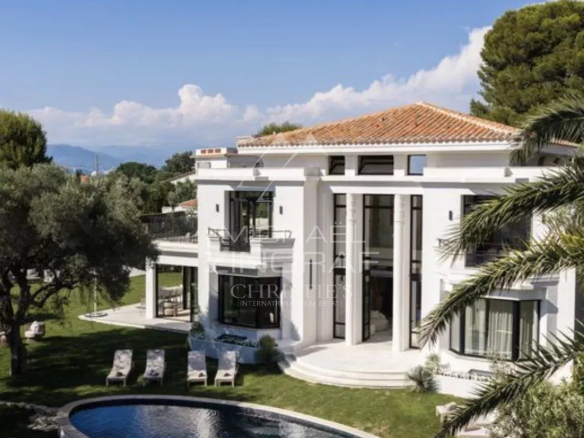 Villa moderne avec piscine et jardin à Cap d'Antibes, vue sur le ciel et la nature environnante.