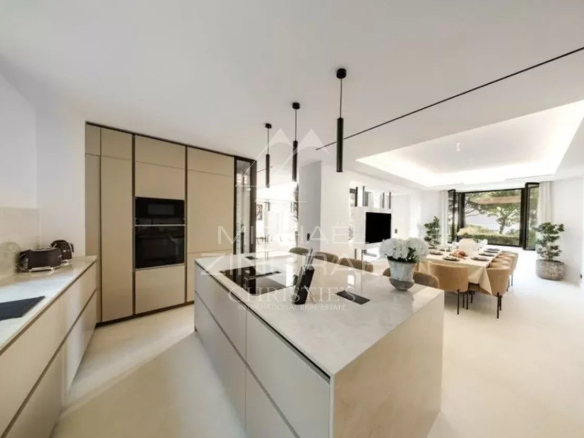 Cuisine moderne et spacieuse d'une villa neuve à Cap d'Antibes, avec salle à manger attenante.