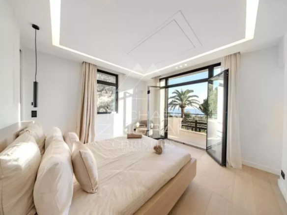 Chambre d'une villa neuve à Antibes avec vue sur des palmiers.