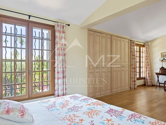 Bright bedroom in a villa in Cap d'Antibes with windows and elegant decor.