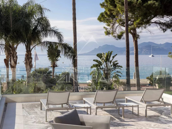 Terrace of an apartment in Cannes with sea view and sun loungers.