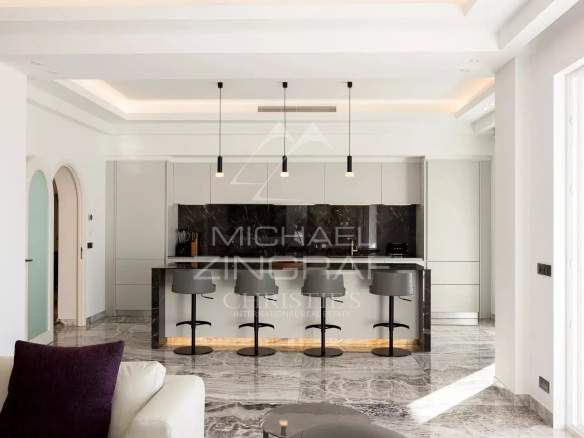 Modern kitchen in a bright apartment in Cannes, with central island and bar.