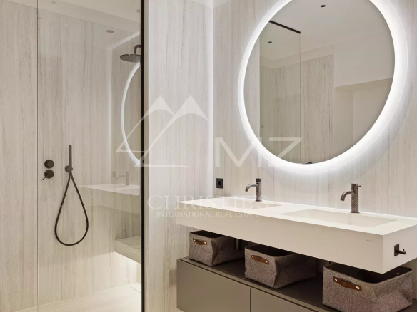 Salle de douche moderne avec douche à l'italienne et miroir rond lumineux.