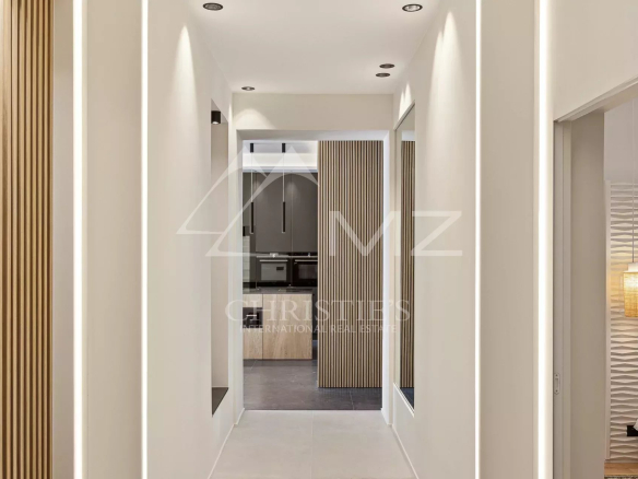 Intérieur d'un appartement moderne avec un couloir lumineux et des murs texturés à Cannes.