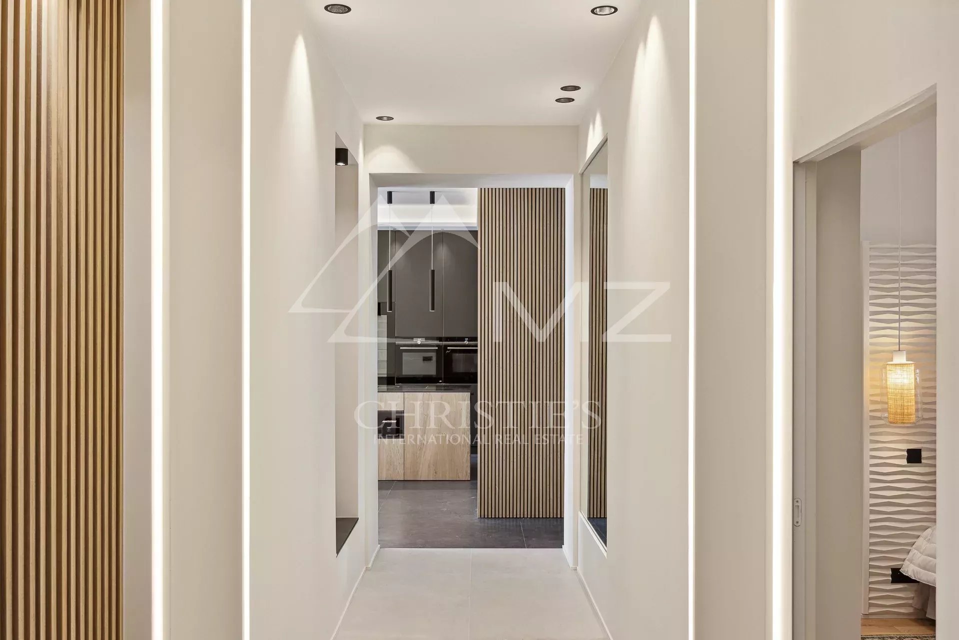 Intérieur d'un appartement moderne avec un couloir lumineux et des murs texturés à Cannes.