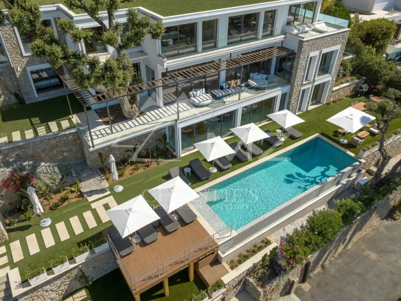 Vue aérienne d'une villa contemporaine avec piscine et terrasse à Cannes, entourée de verdure.