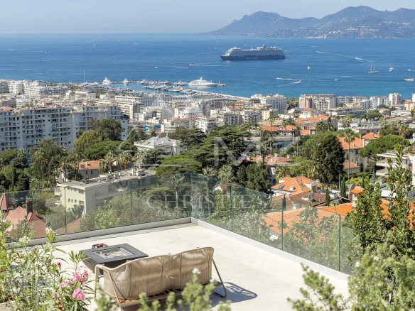 Vue panoramique sur Cannes et la mer depuis une villa contemporaine avec terrasse.