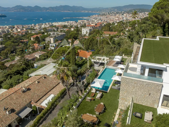 Vue aérienne d'une villa contemporaine avec piscine et mer à Cannes.