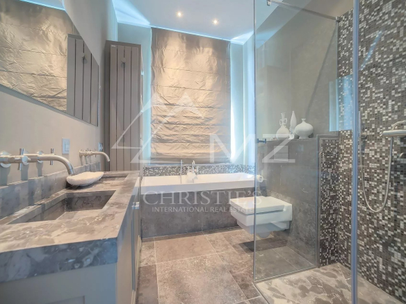 Salle de bains moderne avec baignoire et douche, carrelage en mosaïque, lumière naturelle
