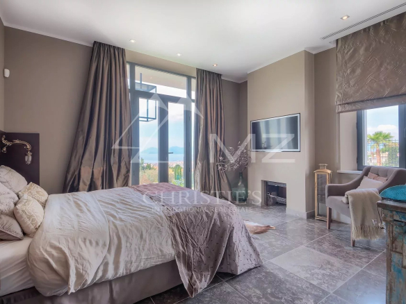 Chambre élégante avec lit, télévision et vue à Cannes.