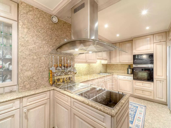 Cuisine moderne avec des meubles en bois clair et des équipements en acier inoxydable.