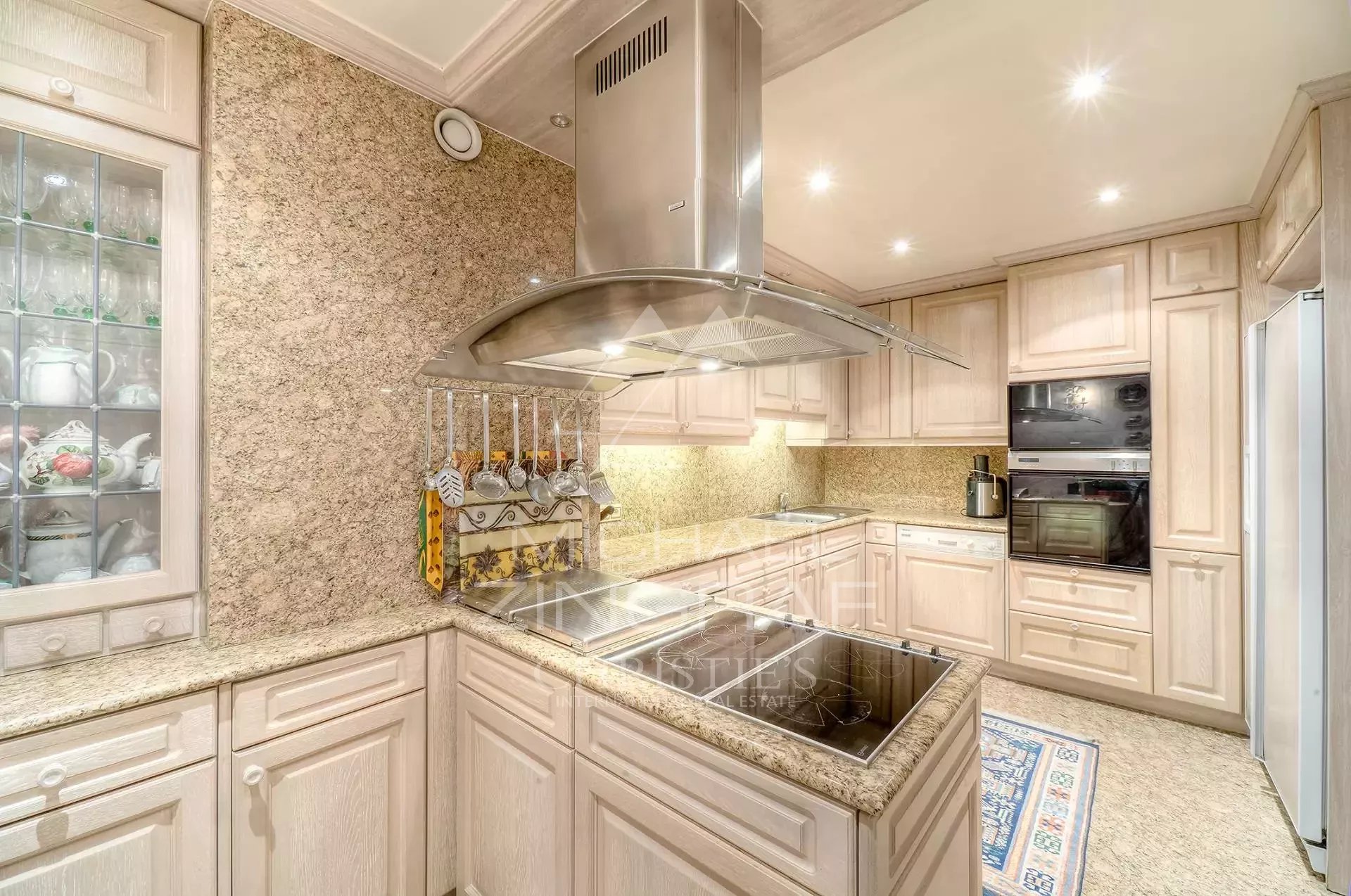 Cuisine d’un appartement de luxe à Cannes Cuisine moderne avec des meubles en bois clair et des équipements en acier inoxydable.