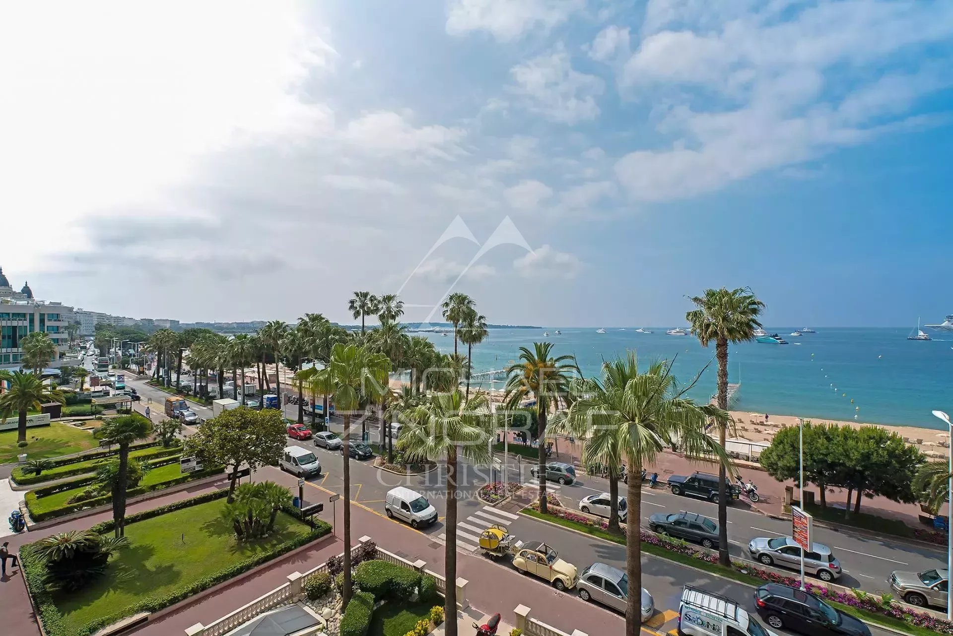 Vue sur la Croisette à Cannes Vue panoramique de la Croisette à Cannes avec des palmiers et la mer en arrière-plan.