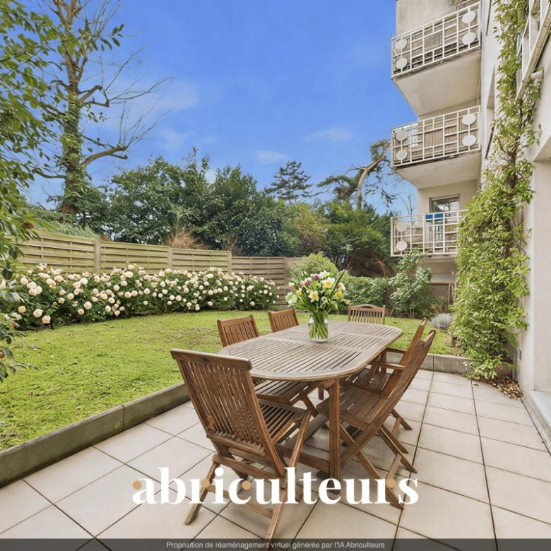 Patio with a wooden dining table and six chairs, a vase of flowers, on a tiled terrace beside a lawn and white rose hedge.