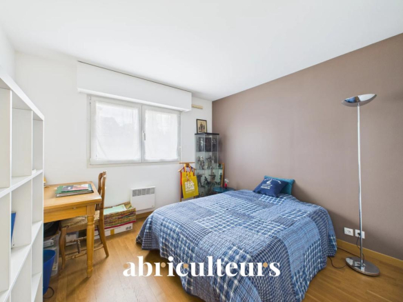 Small bedroom with a single bed, blue plaid duvet, brown accent wall, and a floor lamp by the bed.