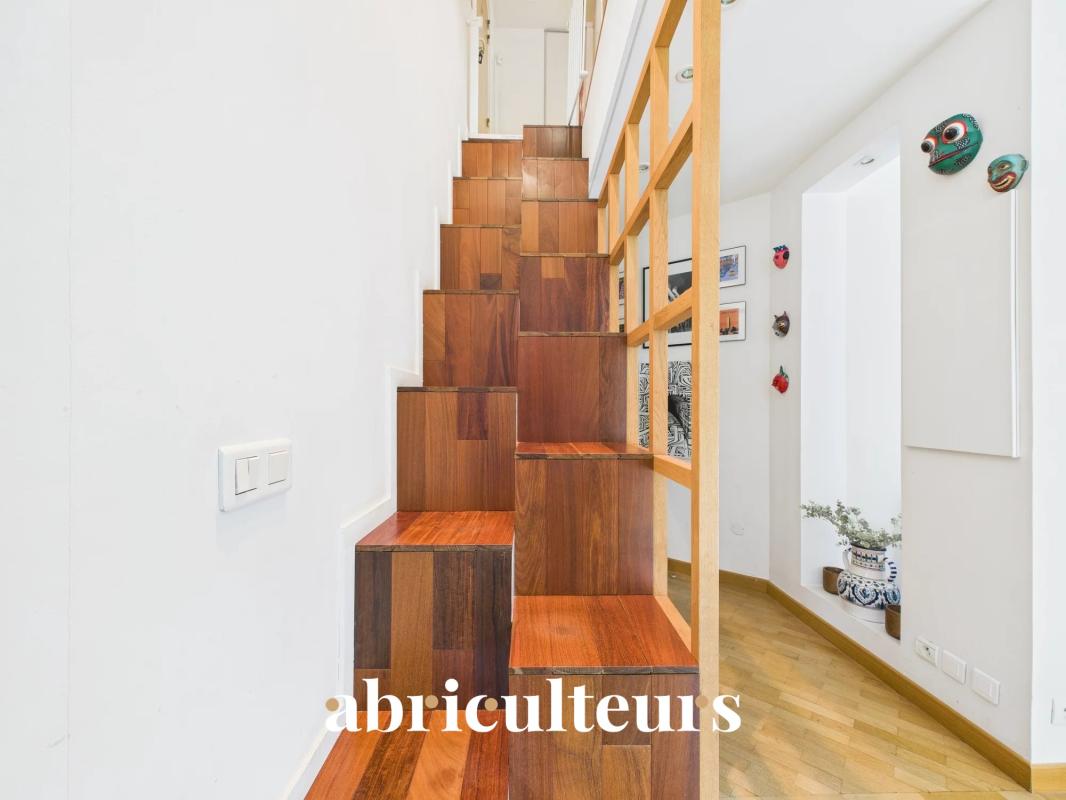 Wooden stair-step mosaic centerpiece in a bright hallway, with a lattice railing and wall decor on the right.