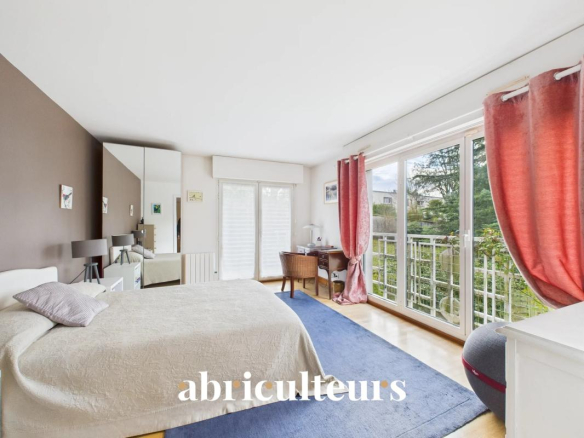 Bright bedroom with a white bed on a brown accent wall, a blue rug, and large glass doors to a balcony with pink curtains.