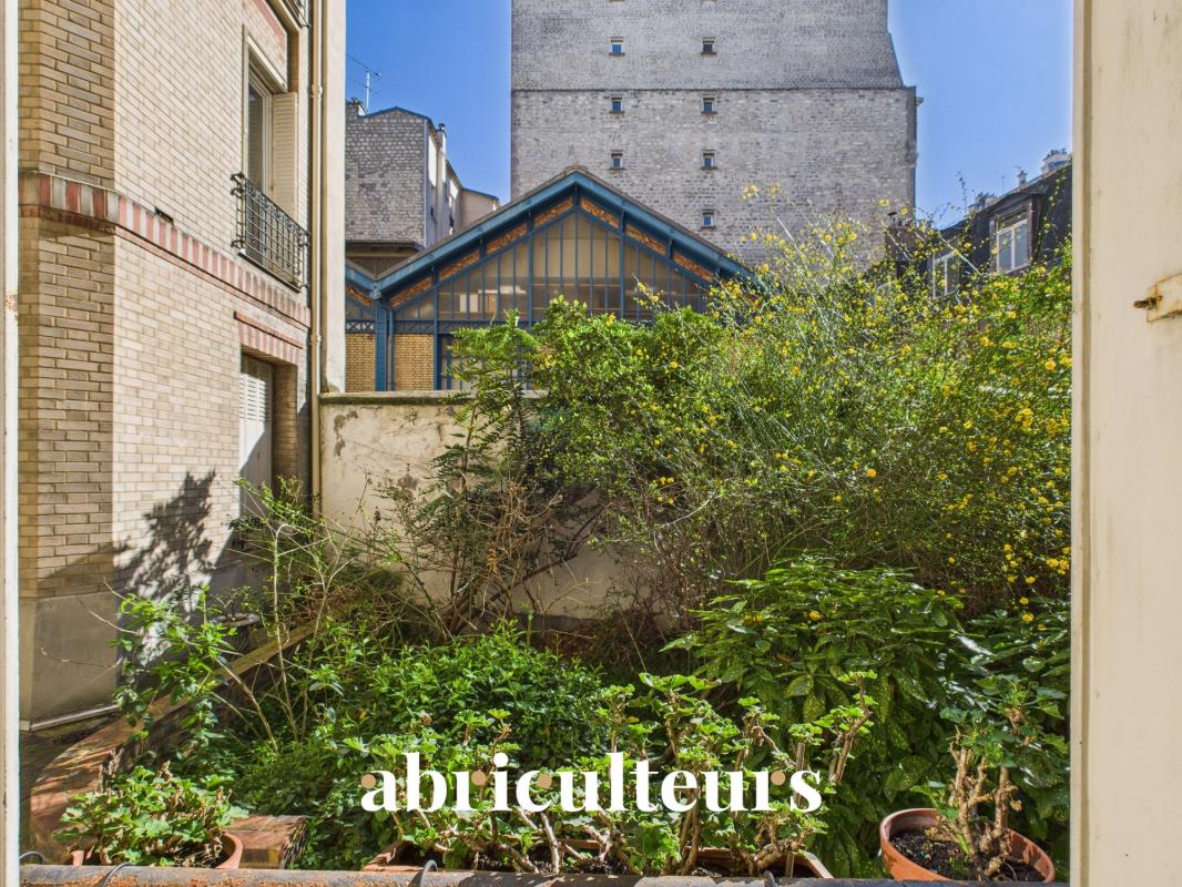 Urban courtyard garden with potted plants and a blue-framed glass conservatory, brick buildings nearby, and the word 'abliculteurs' at the bottom.