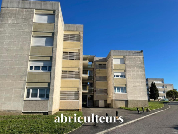 Modern concrete apartment building with beige panels and balconies under a blue sky; the word 'abriculteurs' overlays the bottom.