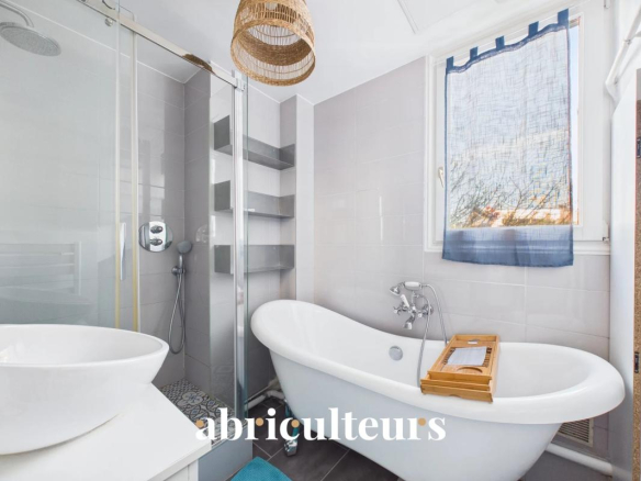 Modern bathroom with freestanding bathtub and shower, natural light.