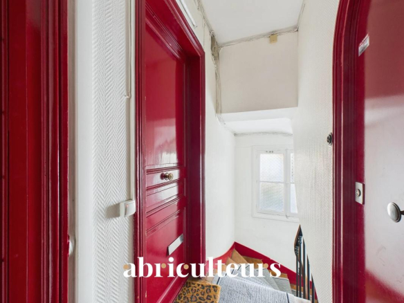 Hallway of an apartment with red doors and a staircase, Paris 16th arrondissement