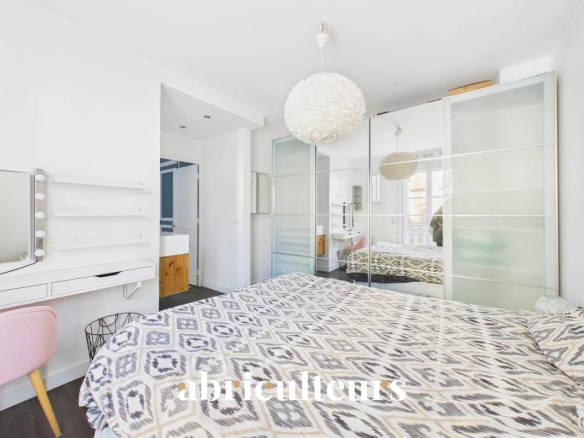 Bedroom in a modern apartment with double bed and mirror, Paris 16th arrondissement.