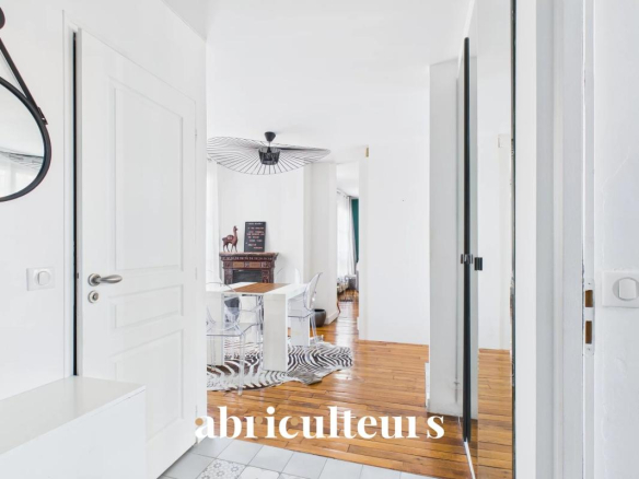 Entrance to a bright apartment with wooden floor and white walls, Paris 16th arrondissement.