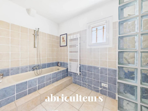 Bathroom in a family home with bathtub and ceramic tile flooring.