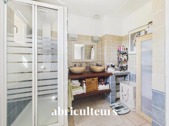 Bathroom with shower, sink and storage in a family home.