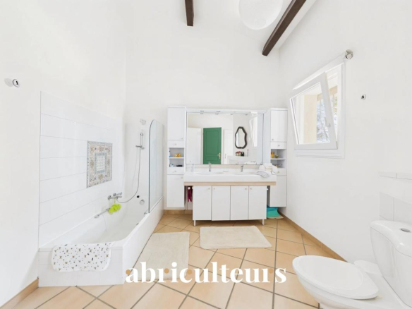 Spacious bathroom with bathtub and shower, decorated in white and beige.