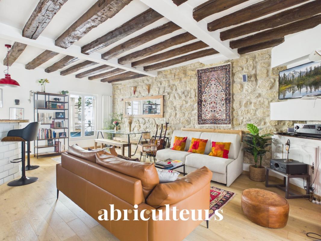 Interior of a two-room apartment with balcony in Paris 11, bright living room with exposed beams.