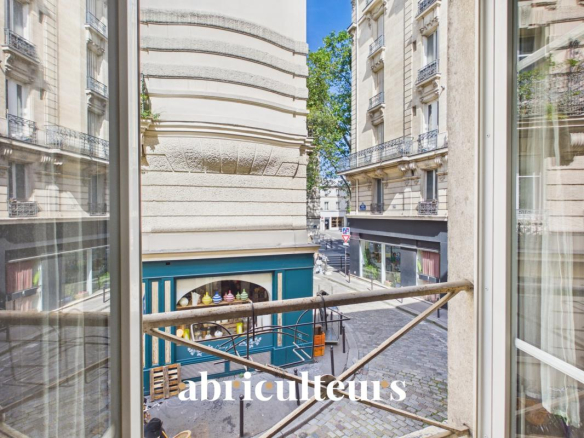 View from the balcony of an apartment in Paris 11, showing a busy street with shops.