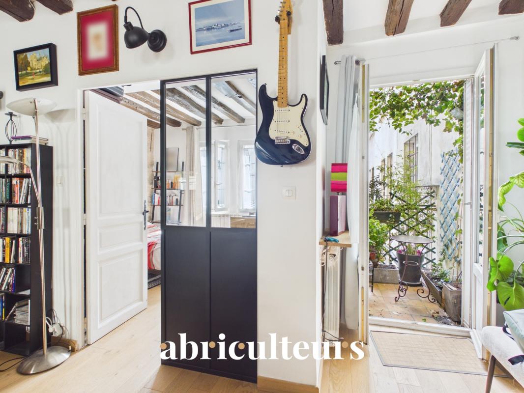 Interior of a two-room apartment with balcony in Paris 11, showing a bright and decorated space.
