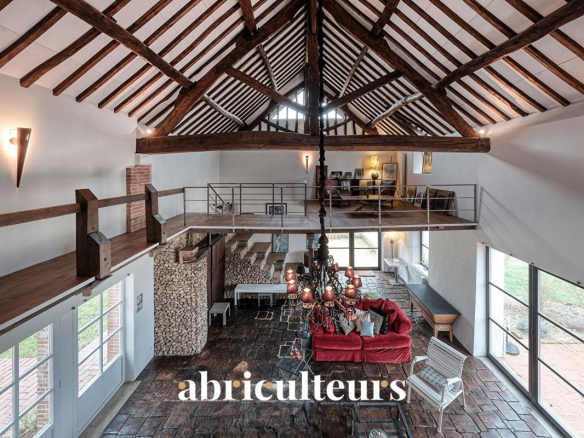 Interior of a renovated 19th century house with exposed beams and bright living space.