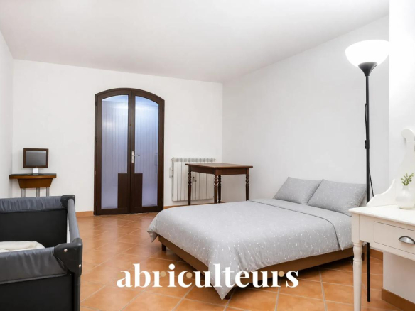 Chambre d'une villa avec lit double, table et chaise, décorée simplement.