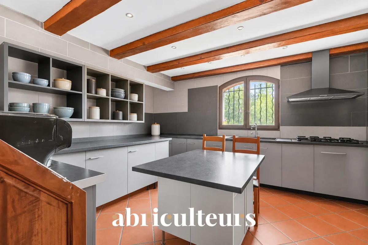 Cuisine de la villa aux Pennes-Mirabeau Cuisine moderne avec des meubles gris et un îlot central dans une villa aux Pennes-Mirabeau.