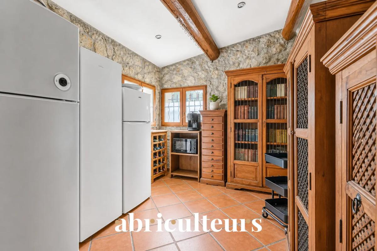 Cuisine de la villa aux Pennes-Mirabeau Cuisine d'une villa avec réfrigérateurs, meubles en bois et murs en pierre.