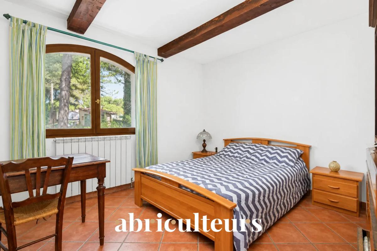 Chambre dans une villa aux Pennes-Mirabeau Chambre avec lit double et décoration simple, fenêtres donnant sur un environnement verdoyant.