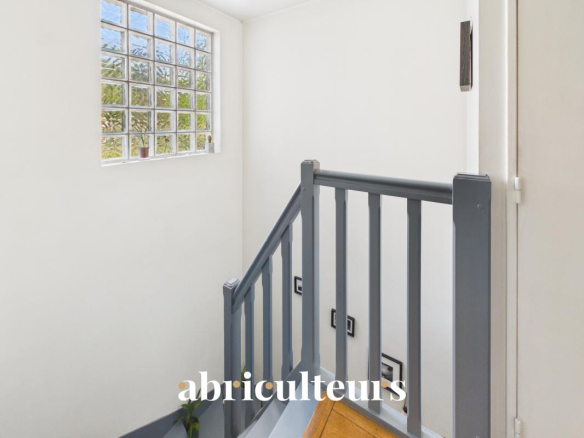 Staircase leading to the upper floor of a duplex in the 20th arrondissement of Paris with natural light.
