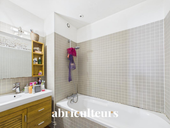 Bathroom with bathtub and sink in a duplex in the 20th arrondissement of Paris.