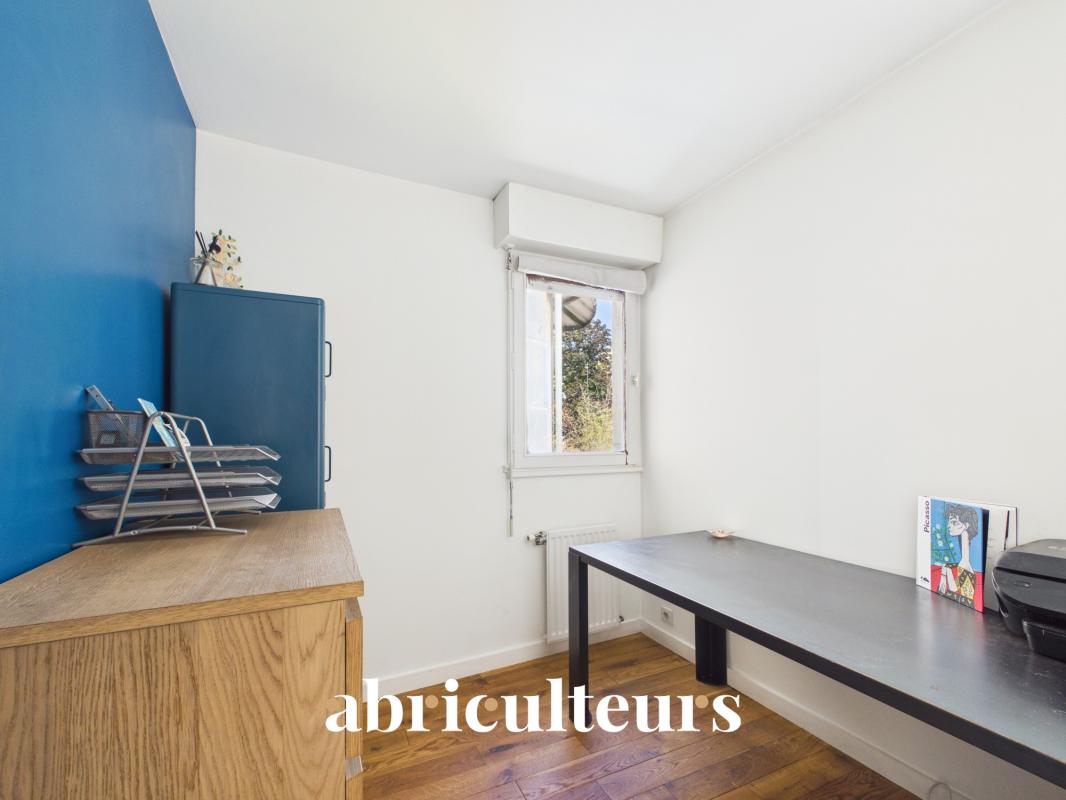 Interior of a duplex in Paris 20th with an office and a wooden piece of furniture.