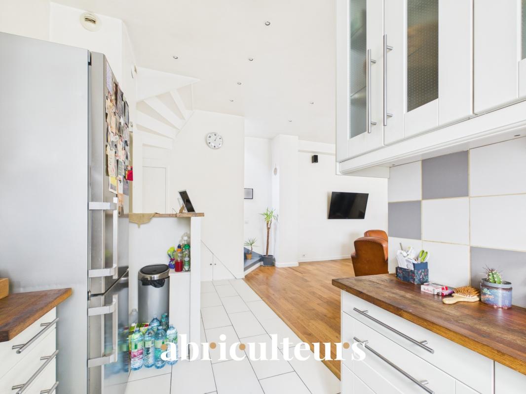 Interior of a duplex in Paris's 20th arrondissement with an open-plan kitchen and bright living room