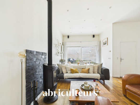 Interior of a duplex in Paris 20th with living room, stove and access to a terrace.