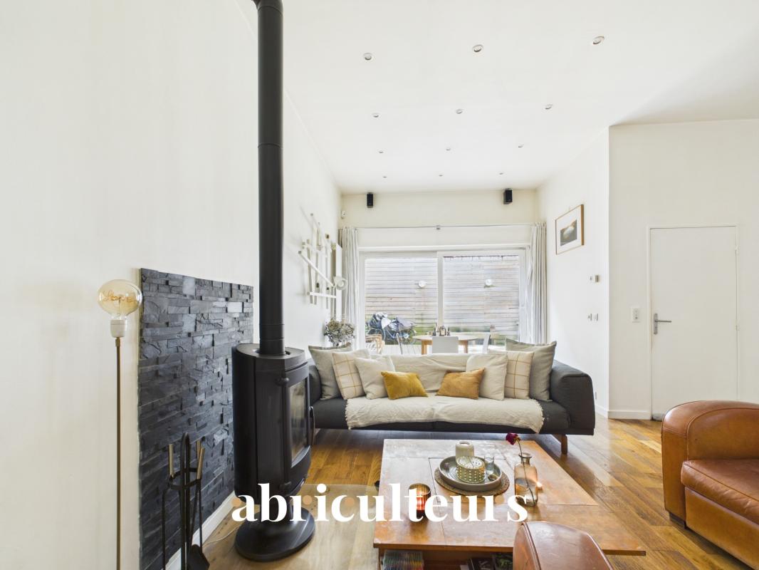 Interior of a duplex in Paris 20th with living room, stove and access to a terrace.