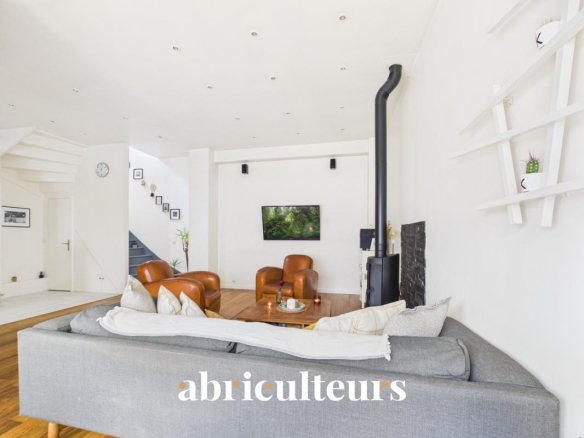 Interior of a duplex in Paris 20th with living room, stove and television.