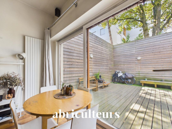 Interior of a duplex with a large wooden terrace, dining table and modern decor.