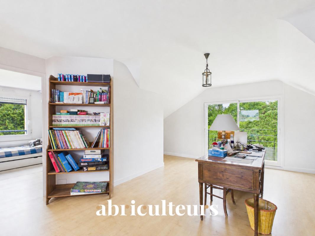Intérieur d’une maison familiale à Carnac Intérieur d'une maison récente avec bureau et bibliothèque, lumière naturelle abondante.