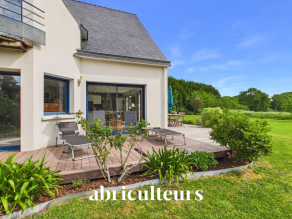 Maison contemporaine avec terrasse et jardin à Carnac, entourée de verdure.
