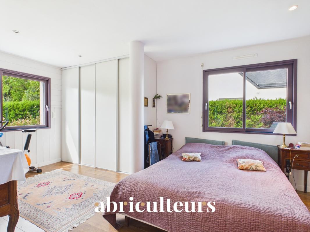 Chambre d’une maison contemporaine à Carnac Chambre d'une maison contemporaine avec lit double et fenêtres donnant sur un jardin.